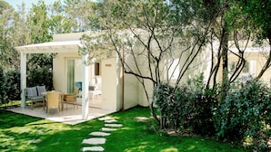 Une maison moderne dotée d’un patio couvert, d’une pelouse et d’un jardin.