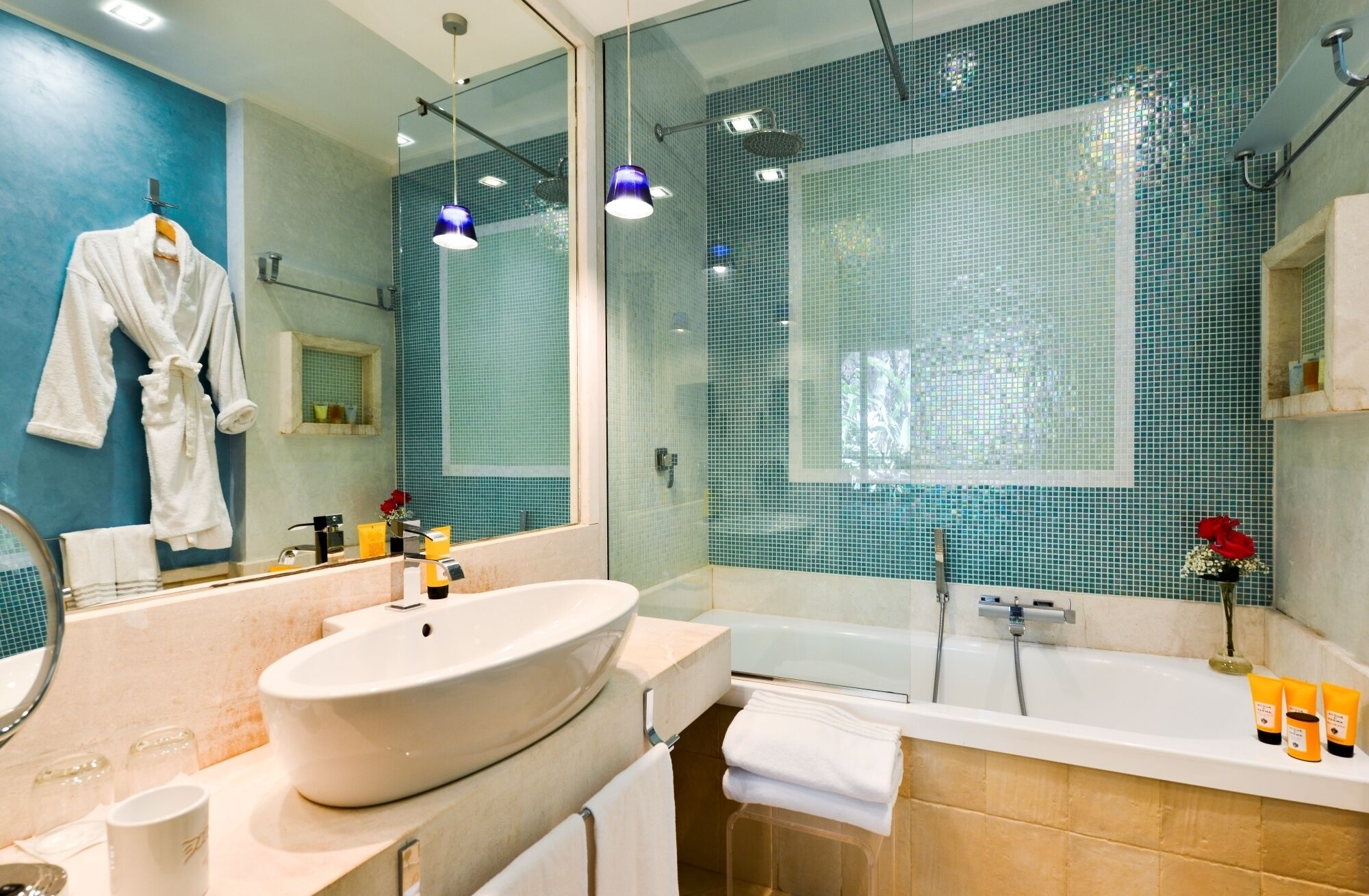 A modern bathroom with a large mirror, a white sink, a bathtub, and a shower area.