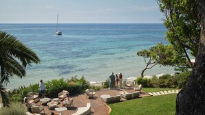 A patio with outdoor furniture, a pool, and a view of the sea. - Forte Village Resort - Il Castello (Pula)