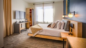 A modern hotel room with a bed, desk, and wardrobe. - The Monterey Motel (Albuquerque)