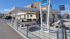 A motel with outdoor seating and a sign advertising a cocktail bar. - The Monterey Motel (Albuquerque)