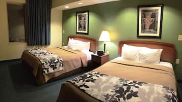 Una habitación de hotel con dos camas, una mesita de noche con lámpara y obras de arte en las paredes.