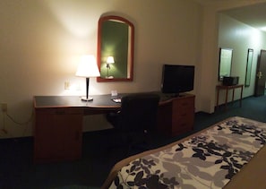 A hotel room with a bed, a desk with a lamp, a television, and a mirror. - Sleep Inn & Suites Danville Hwy 58 (Danville)