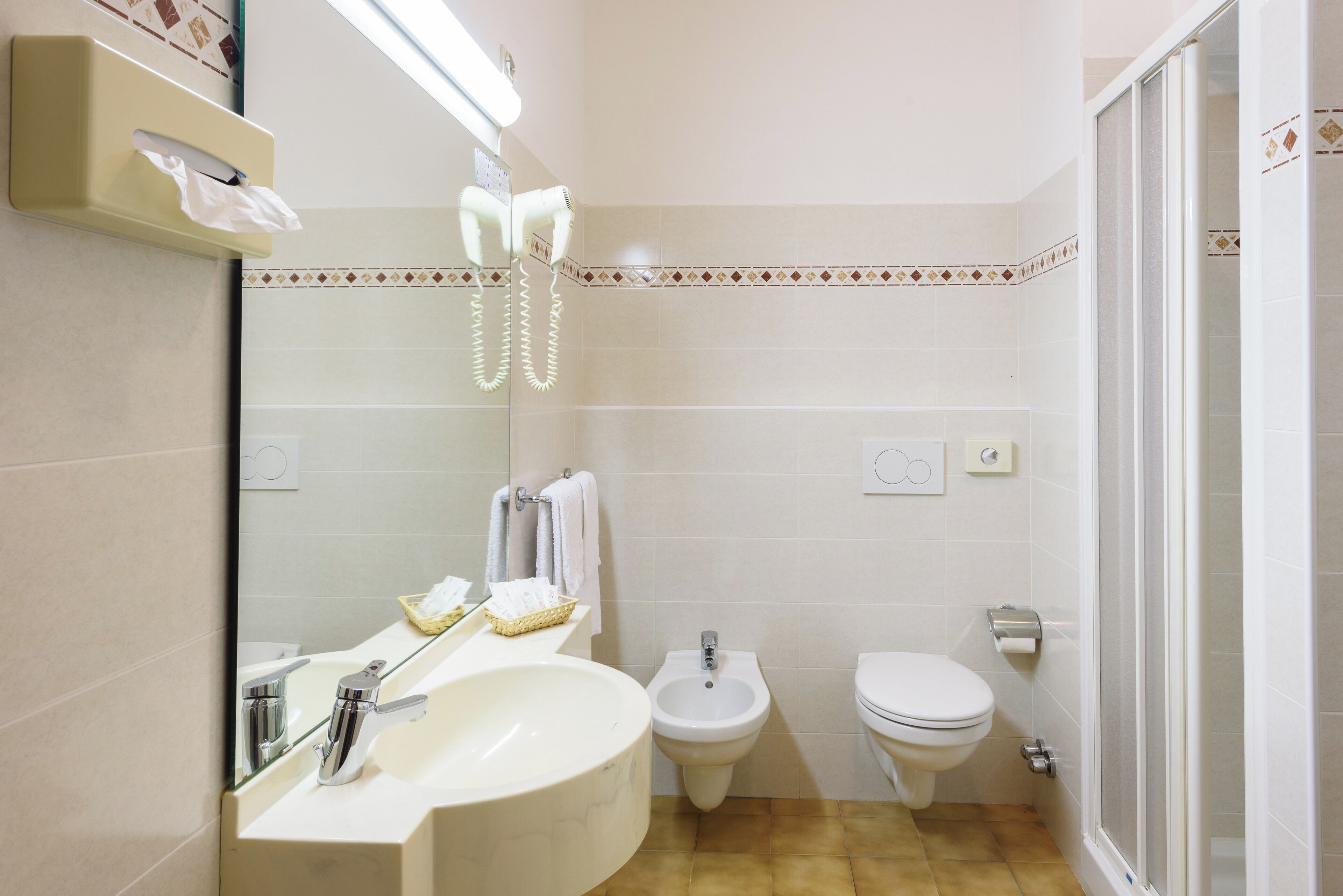Un baño con lavabo, bidé, inodoro y espejo.