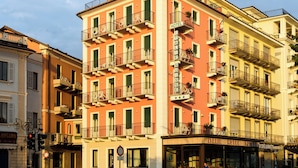 A multi-story hotel with balconies, a crosswalk, and a street view. - Hotel Italie Et Suisse (Stresa)