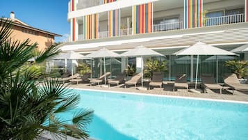 Piscine couverte, piscine extérieure, parasols de plage, chaises longues