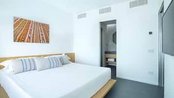 Ein modernes Hotelzimmer mit einem großen Bett, einem Badezimmer mit Spiegel und Blick auf den Flur.