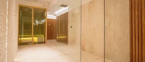 A modern elevator with glass doors, a wooden panel wall, and a lighted interior.