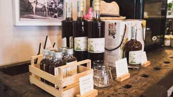 Una caja de madera con botellas de vino y copas, una fotografía antigua y un cartel que muestra los precios del vino.