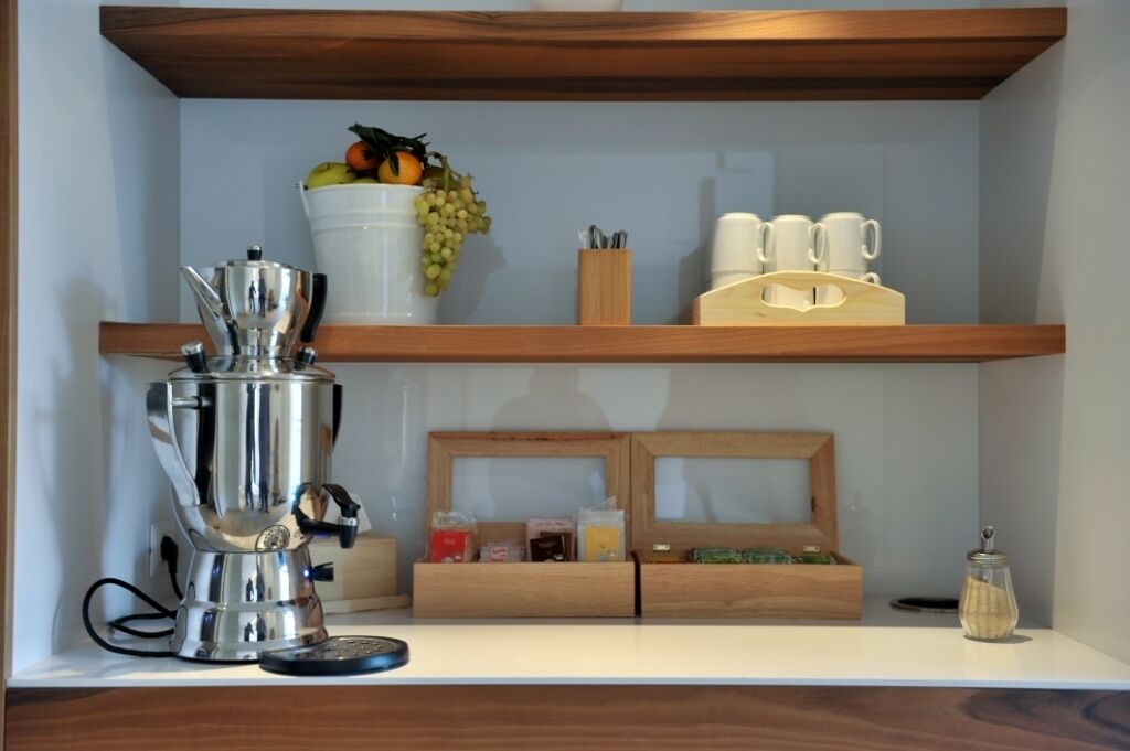 A kitchen counter with a coffee machine, a fruit bowl, and a coffee station.