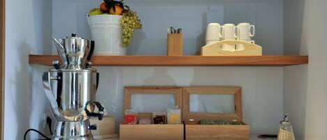 A kitchen counter with a coffee machine, a fruit bowl, and a coffee station.