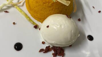 Postre amb una bola de gelat sobre un plat blanc.
