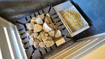 A metal grate filled with rocks and a box containing gravel.