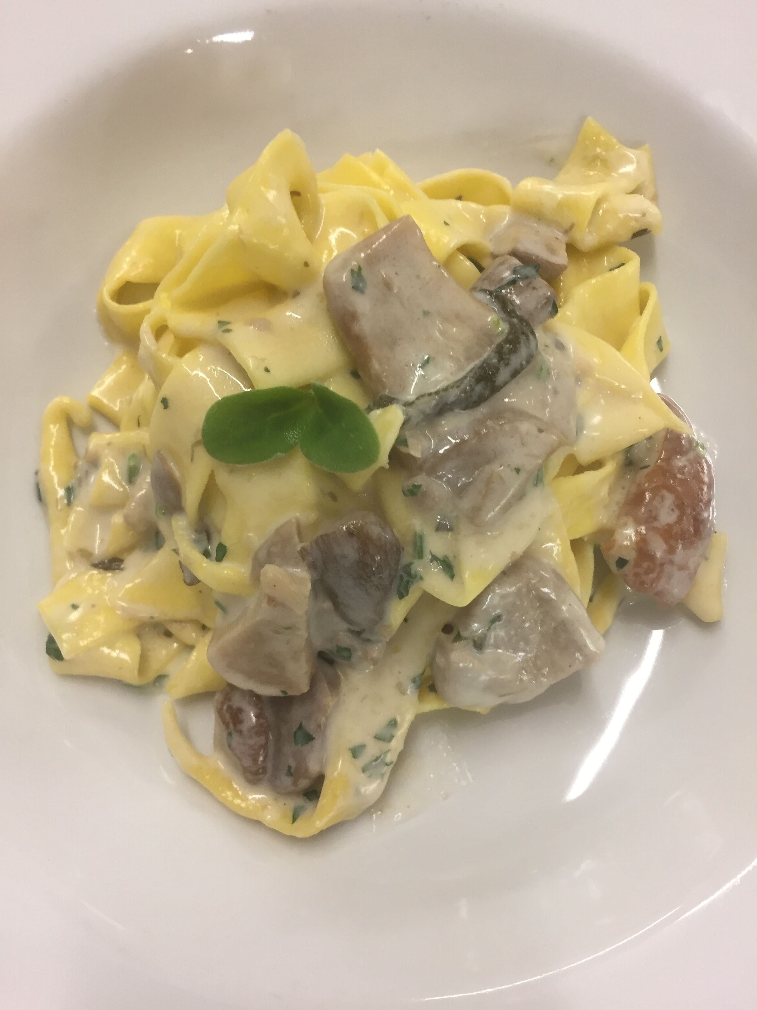 Eine Portion Pasta mit cremiger Soße und Fleischstückchen.