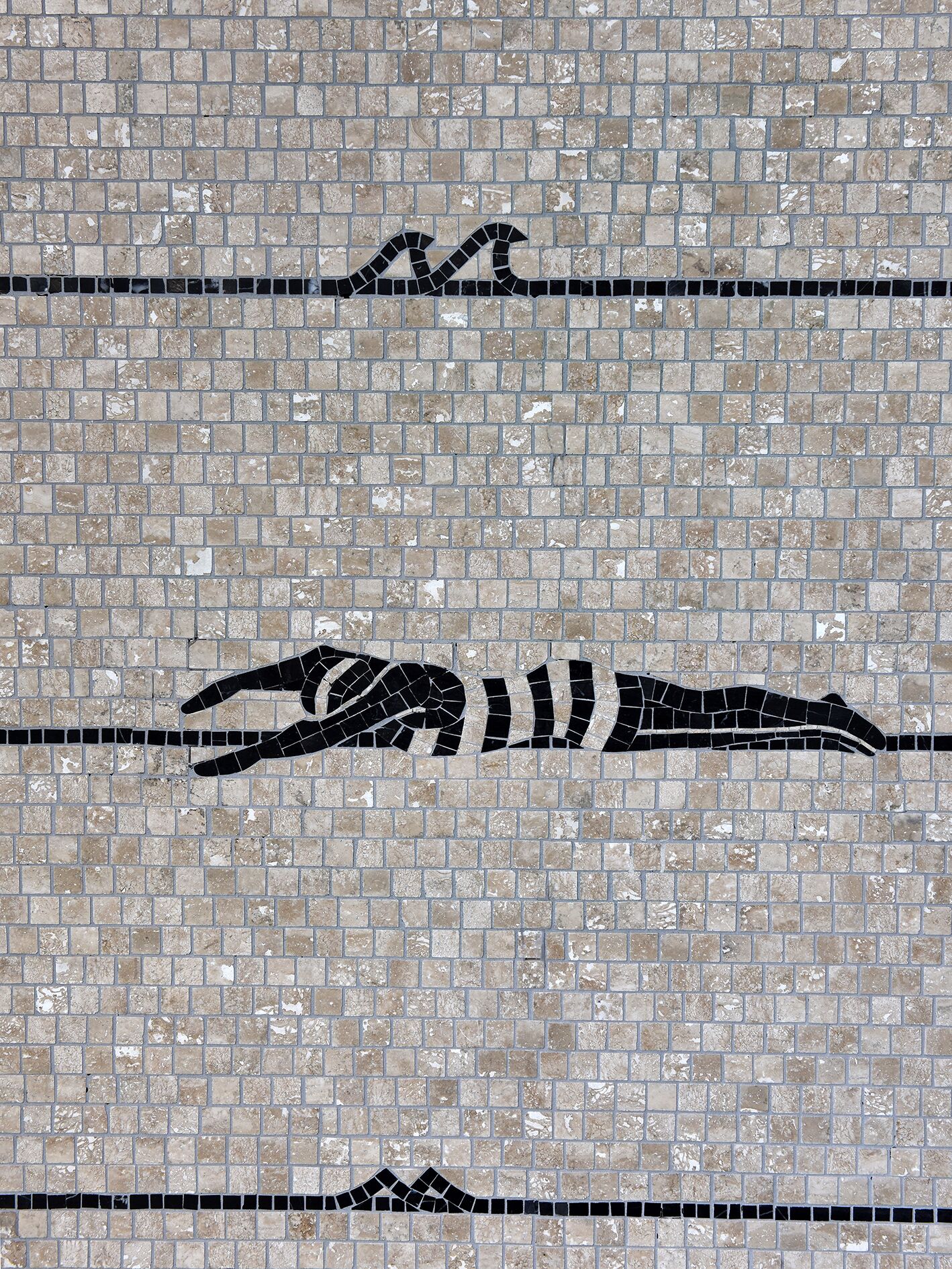 A mosaic wall with a pattern of interlocking tiles.
