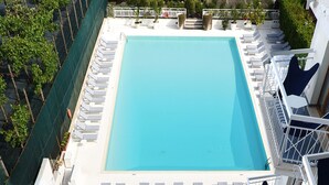 A rooftop pool with lounge chairs and a palm tree. - Grand Hotel Flora (Sorrento)