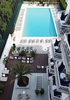 Una piscina al aire libre, sillones reclinables de piscina