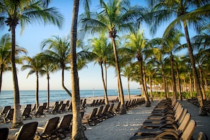On the beach, white sand, sun loungers, beach umbrellas