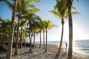 On the beach, white sand, sun loungers, beach umbrellas