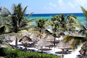 On the beach, white sand, sun loungers, beach umbrellas