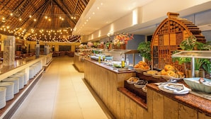 Un espace buffet avec un comptoir en bois, divers plats et une plante décorative.