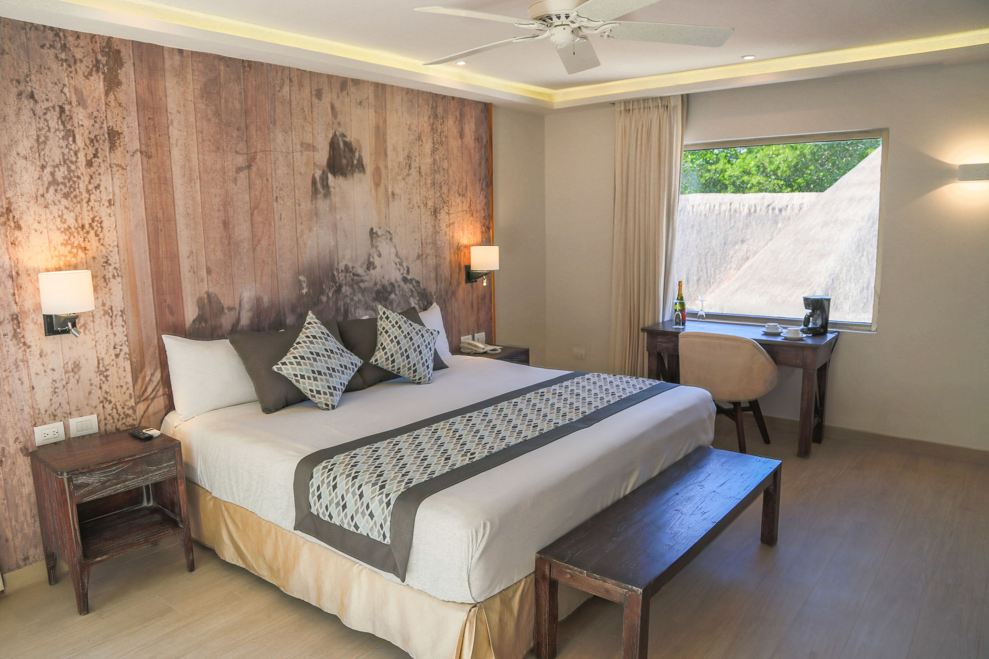 Ein Schlafzimmer mit einem großen Bett, Nachttischen, einem Schreibtisch und einem Stuhl.
