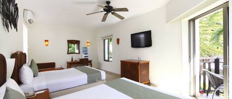 Quarto de hotel com duas camas, uma escrivaninha, televisão e varanda com mobiliário.