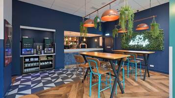 A modern cafe interior with a bar area, seating, and a neon sign.