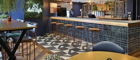A bar area with a counter, stools, and a menu board listing drinks.