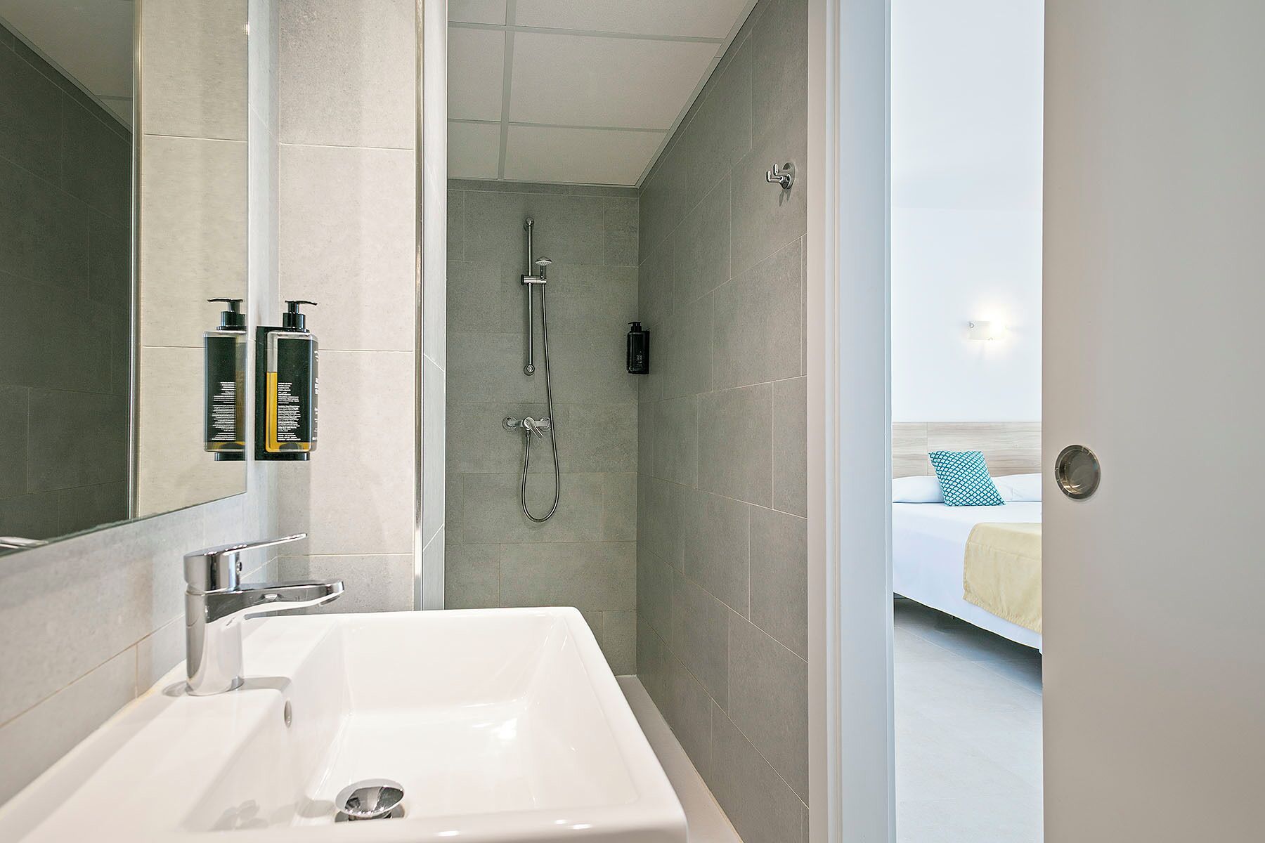 A modern bathroom with a sink, mirror, and shower.