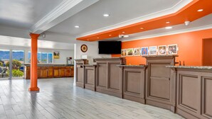 Una cocina amplia con una isla grande, armarios de madera y un televisor de pantalla plana montado sobre la isla.