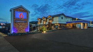 Un motel con un llamativo letrero con el número '6', un cartel de 'Bienvenido' y el logotipo de McDonald's.