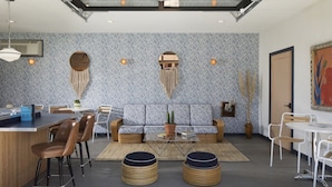 A modern living room with a sofa, chairs, a coffee table, and a dining area with a table and chairs. - The Sandman Santa Rosa Sonoma, an Ascend Collection Hotel (Santa Rosa)