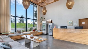 A modern hotel lobby with a large seating area, a wooden reception desk, and large windows offering a view of the outdoors. - The Sandman Santa Rosa Sonoma, an Ascend Collection Hotel (Santa Rosa)