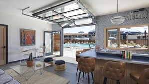 A modern kitchen with a large island, bar stools, and a view of a pool. - The Sandman Santa Rosa Sonoma, an Ascend Collection Hotel (Santa Rosa)