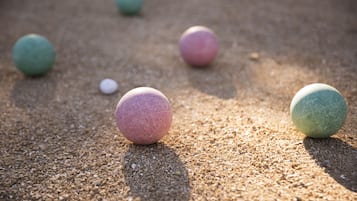 A sandy surface with several spherical objects.