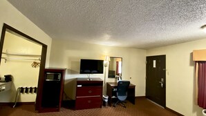 A hotel room with a desk, chair, television, and a wardrobe. - Super 8 by Wyndham Shawnee (Shawnee)