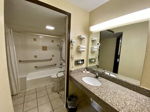 Une salle de bain équipée d’une baignoire, de toilettes et d’un lavabo. On y trouve également des sèche-mains et un porte-serviettes.