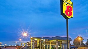 A Super 8 hotel with a large sign, multiple buildings, and a parking lot. - Super 8 by Wyndham Shawnee (Shawnee)