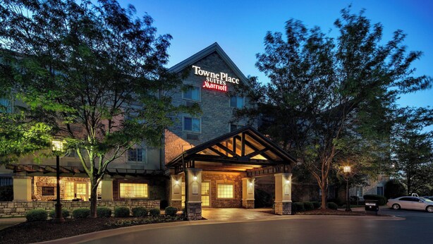 Towne Place Suites Marriott con fachada de piedra, entrada cubierta y un cartel de bienvenida.