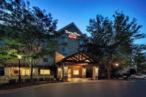 Towne Place Suites Marriott con fachada de piedra, entrada cubierta y un cartel de bienvenida.