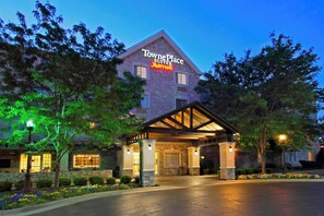 Experience a serene atmosphere at Towne Place Suites, surrounded by beautifully maintained gardens and a covered patio area.