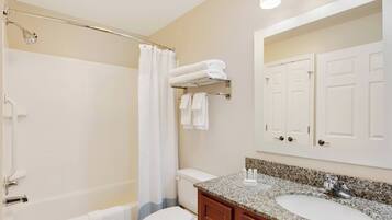A bathroom with a bathtub, toilet, and sink.