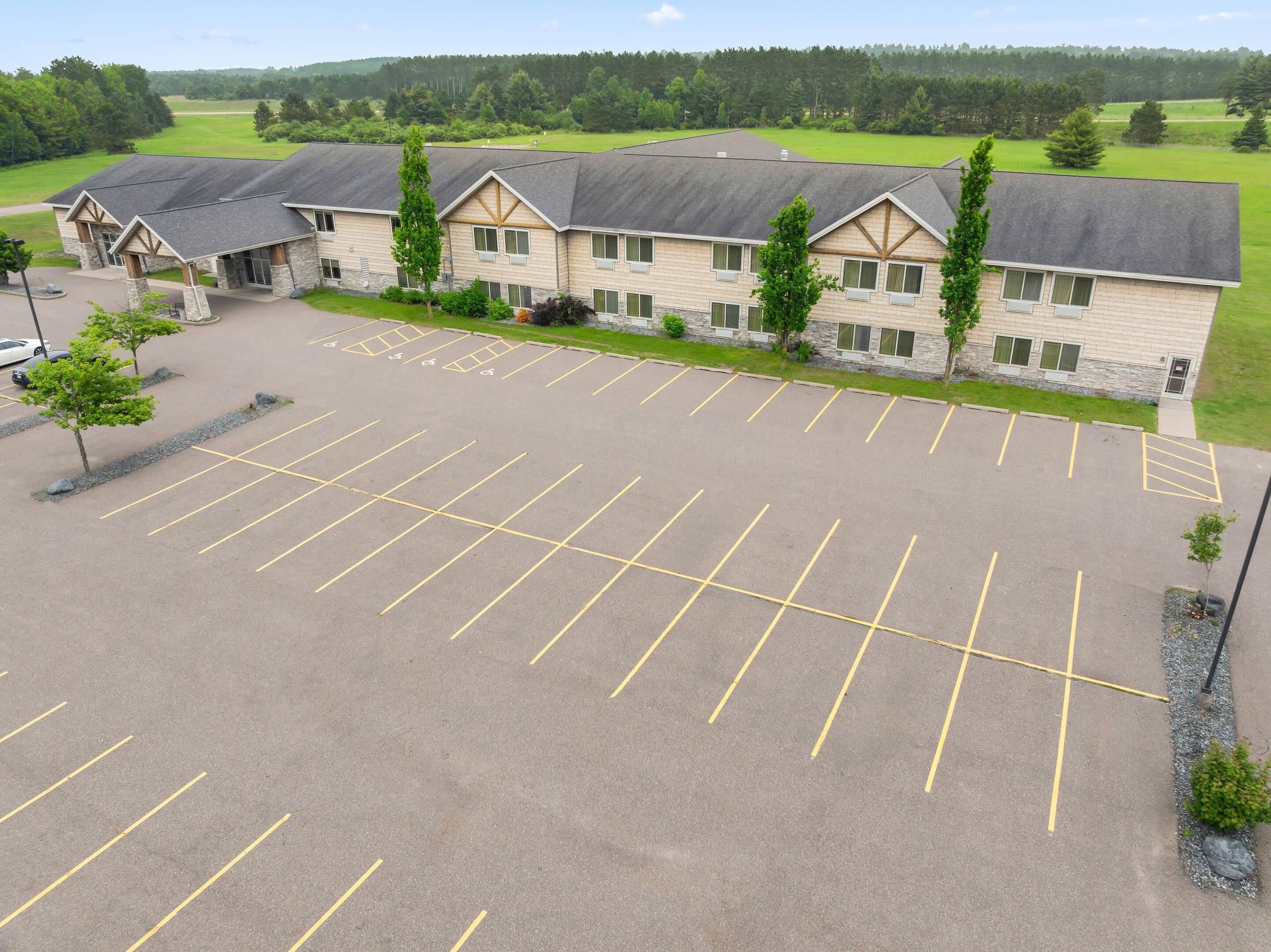 Een groot, meerhoog hotel met een parkeerplaats ervoor.