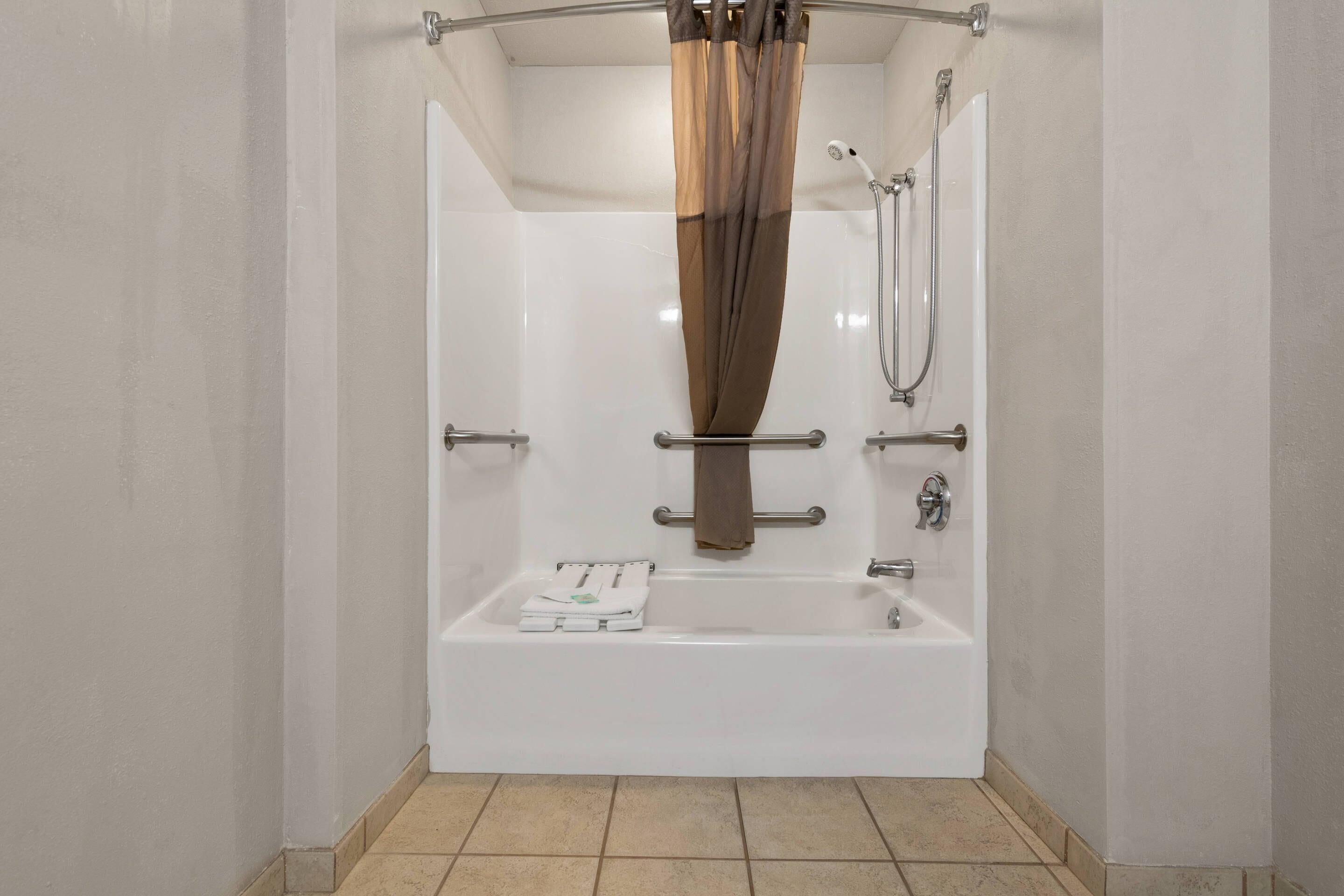 Une salle de bain moderne équipée d’une baignoire, d’une douche et d’un porte-serviettes.