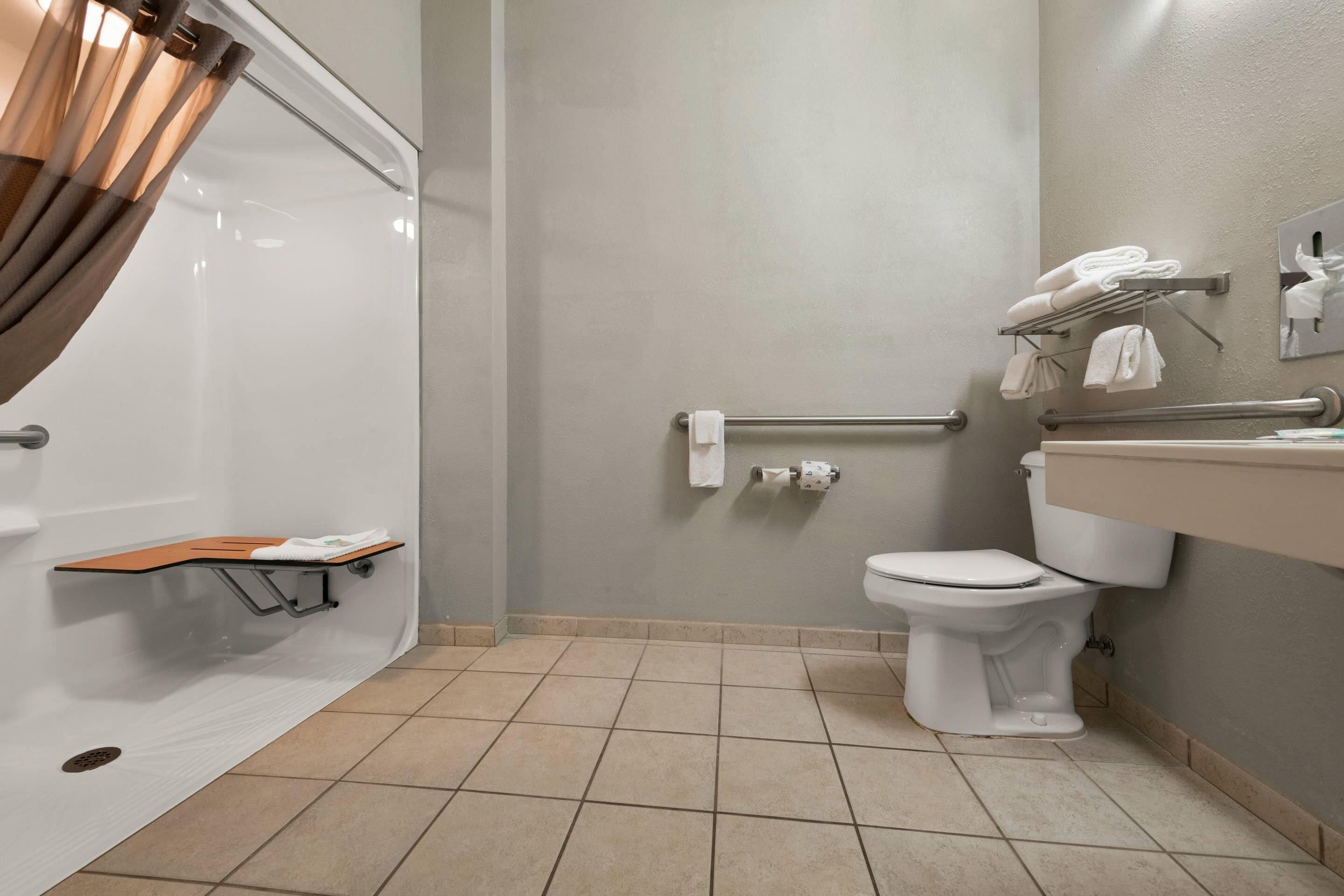 A bathroom with a shower, toilet, and sink.