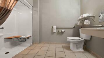A bathroom with a shower, toilet, and sink.