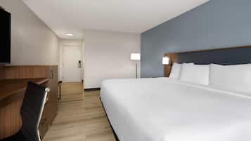 Una habitación de hotel con una cama grande, un escritorio y una silla.
