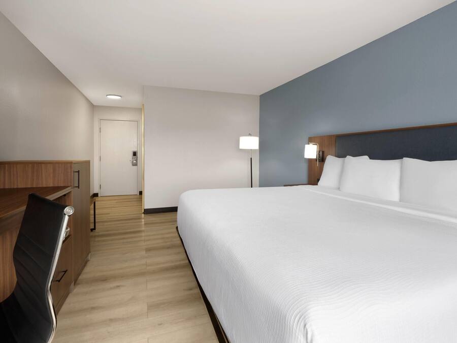 Una habitación de hotel con una cama grande, un escritorio y una silla.