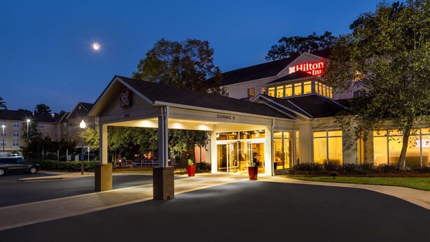 A hotel entrance with a covered walkway, a clear sky, and a visible moon. - Hilton Garden Inn Montgomery East (Montgomery)